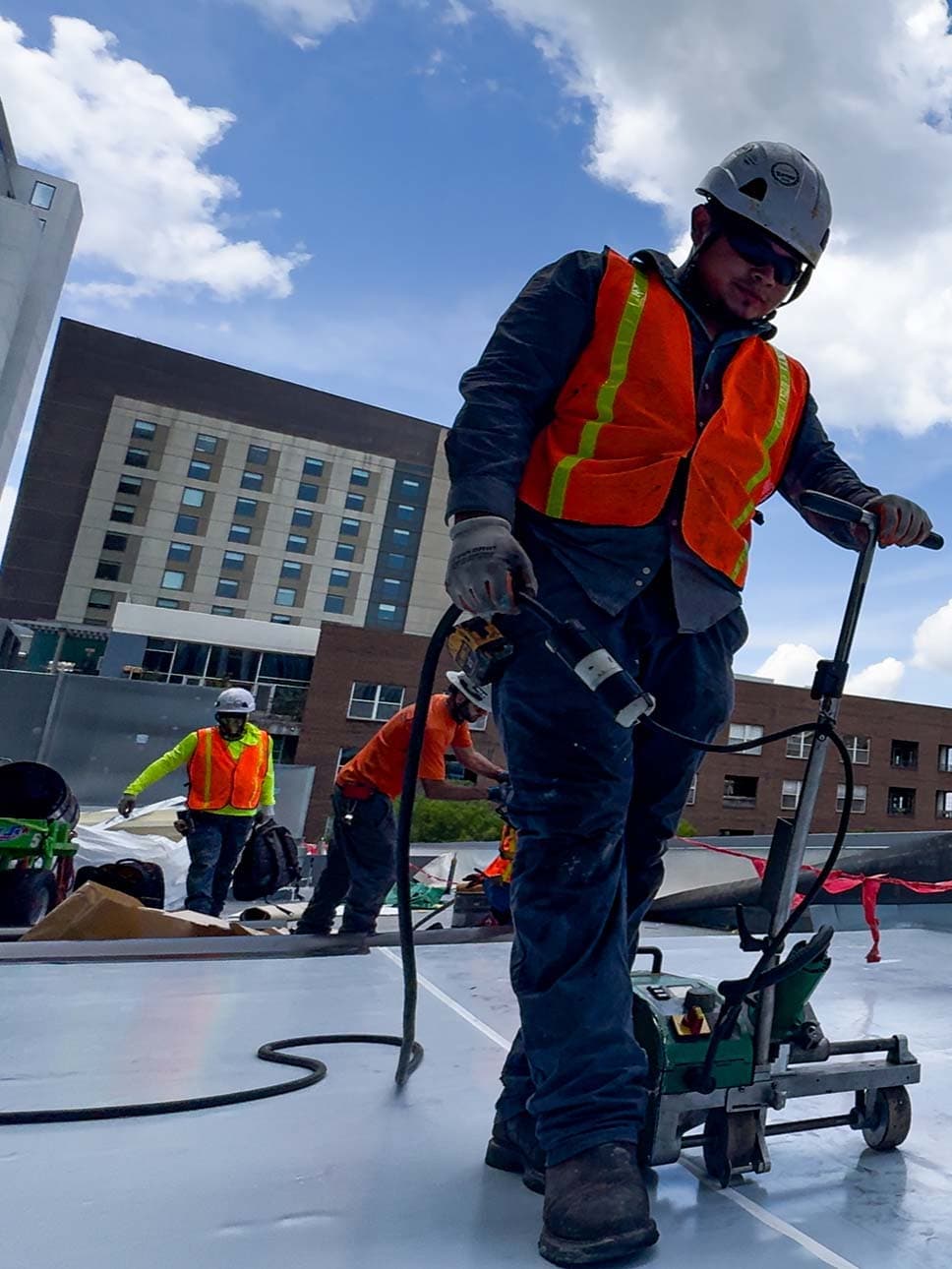 commercial roofer guiding a heating machine